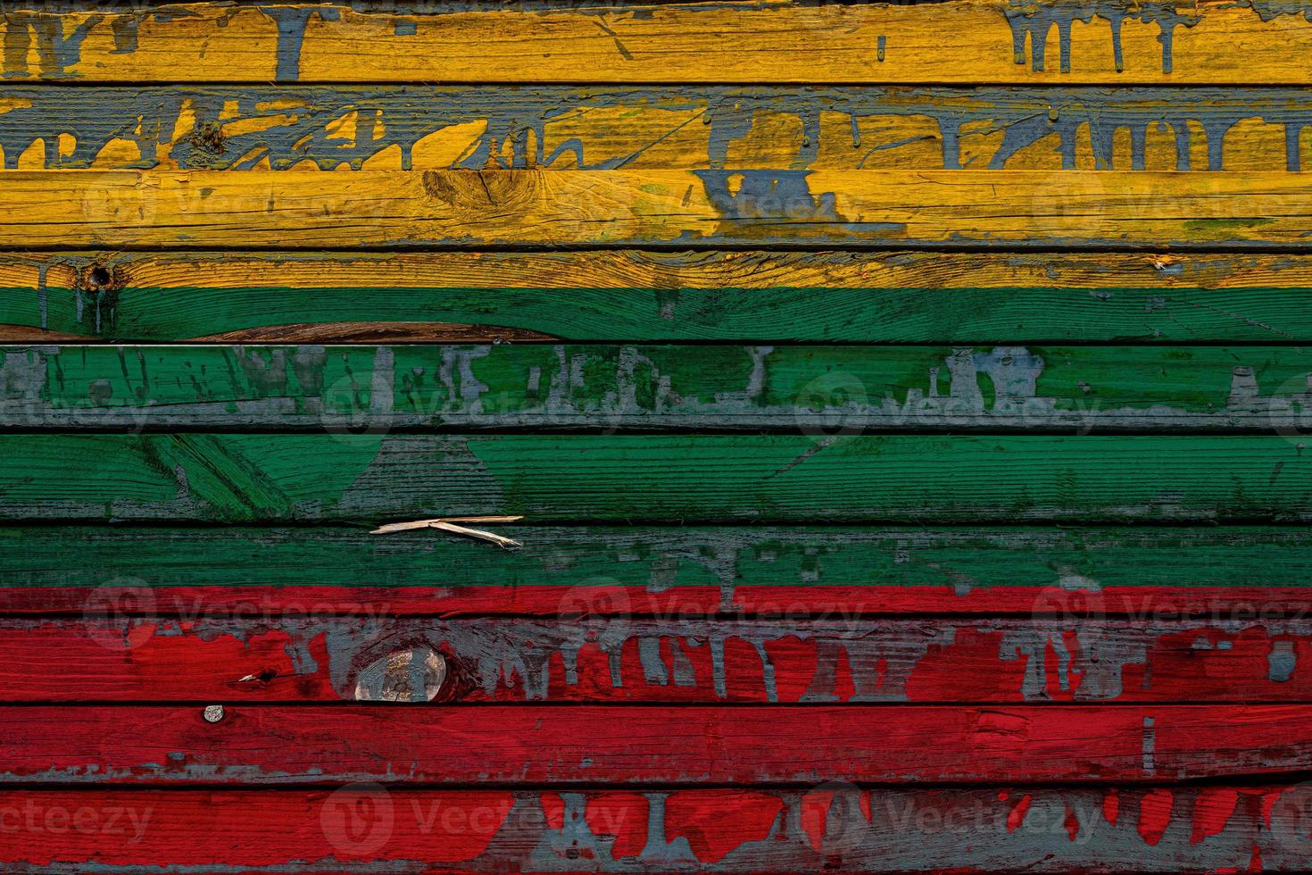 The national flag of Lithuania is painted on uneven boards. Country symbol. photo