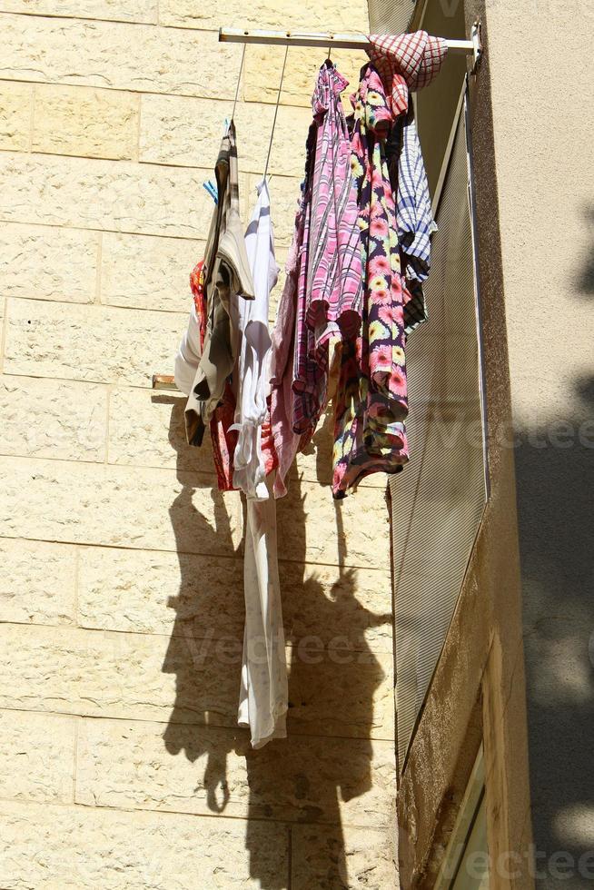 Washed linen dries on the street outside the window of the house. photo