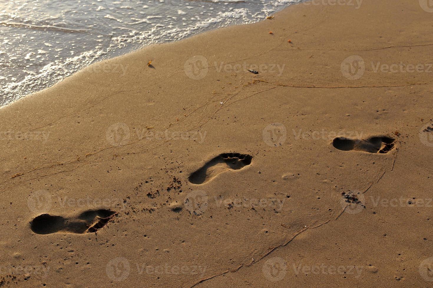 Footprints in the sand on the city beach. photo