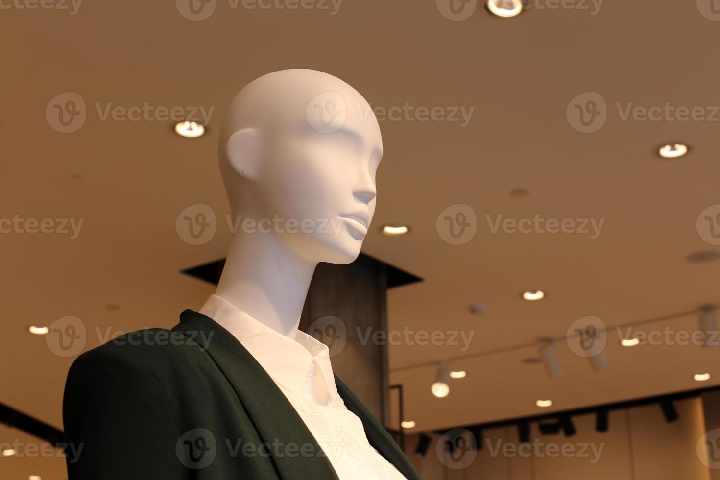 A mannequin stands on a showcase in a large store. photo