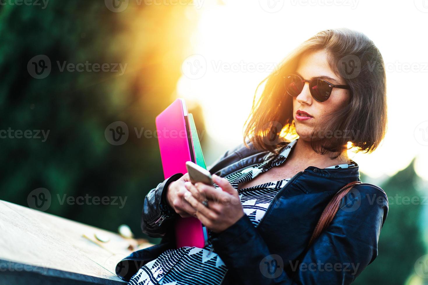 Young student beautiful girl walking in the city with books  com photo