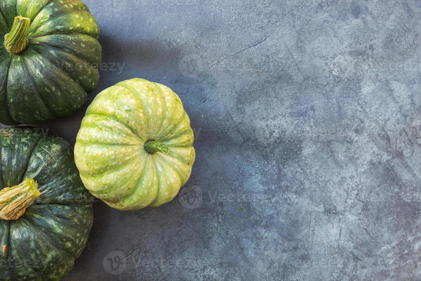 Autumnal Background. Natural autumn fall view pumpkins on dark black stone shale background. Change of seasons ripe organic food concept, Halloween party Thanksgiving day. Flat lay top view copy space photo