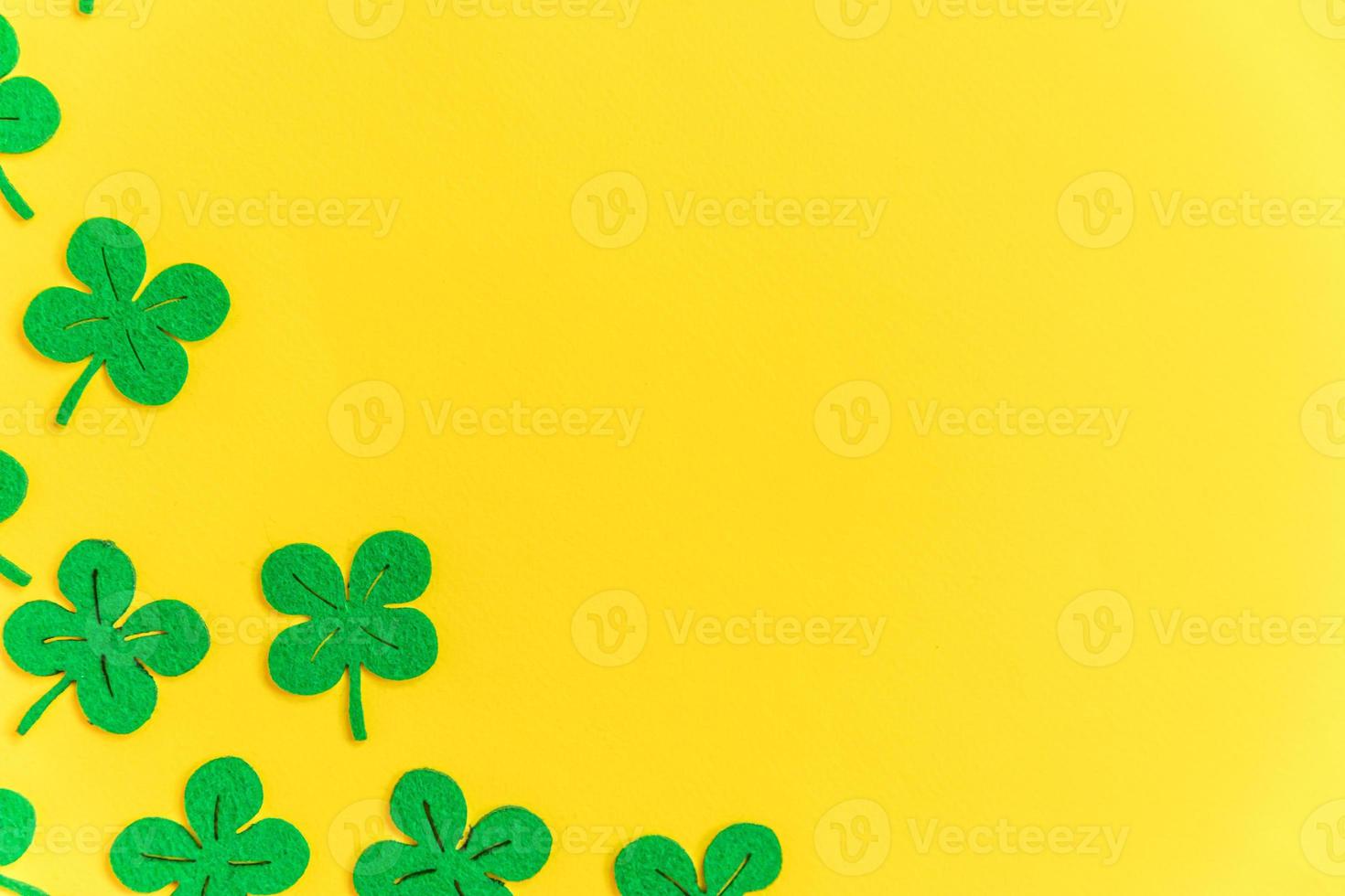 fondo del día de san patricio. diseño simplemente minimalista con trébol verde. hojas de trébol aisladas sobre fondo amarillo. símbolo de irlanda. concepto de deseo de fortuna suerte. espacio de copia de diseño de vista superior plana. foto