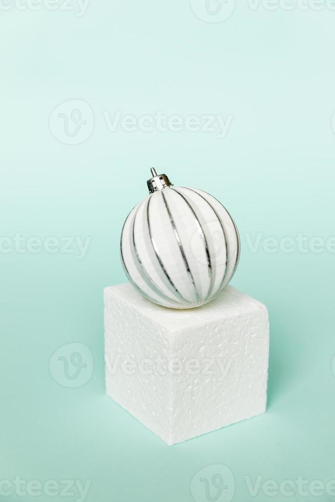 Simply minimal composition winter objects ornament and cube shapes geometric form podium isolated blue pastel background. Christmas New Year december time for celebration concept. Mockup, copy space photo