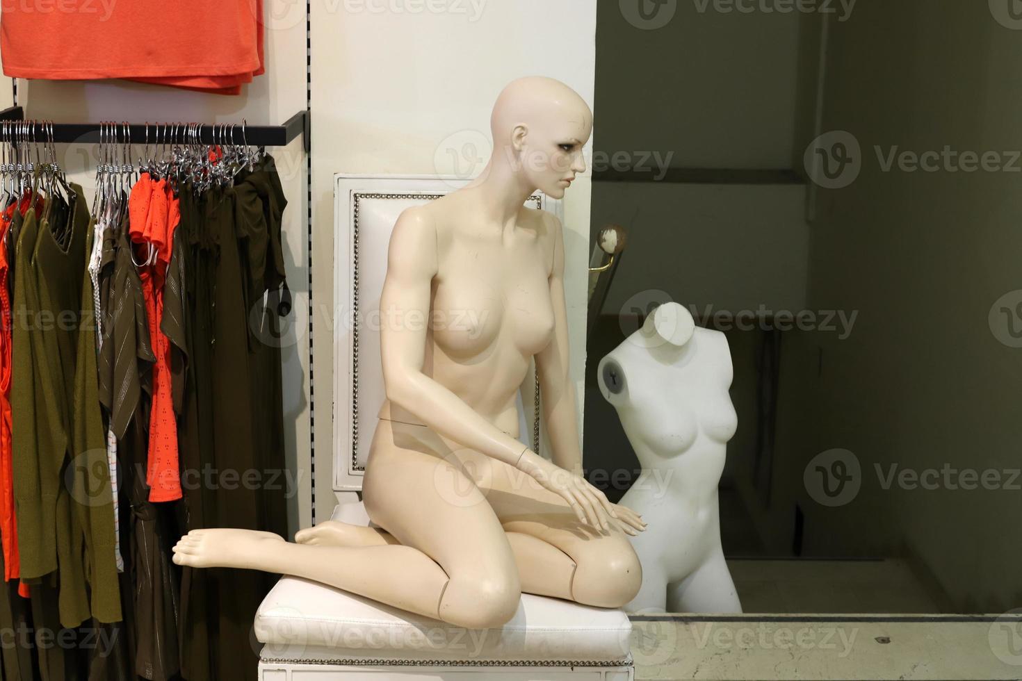A mannequin stands on a showcase in a large store. photo