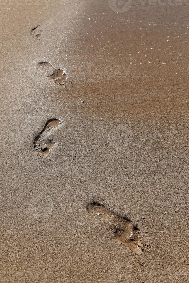 Footprints in the sand on the city beach. photo