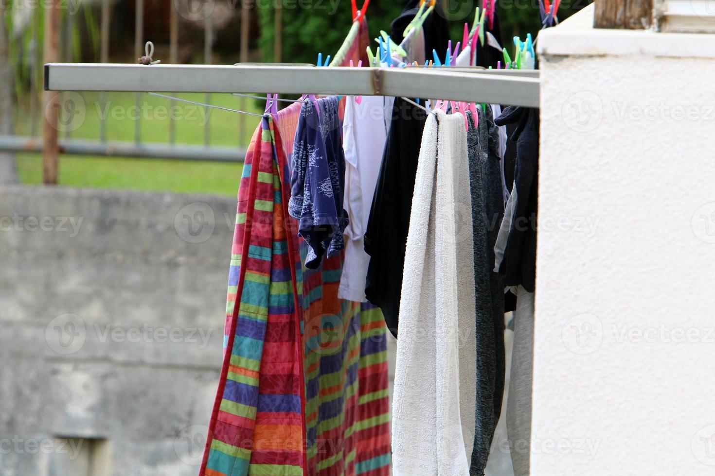 Washed linen dries on the street outside the window of the house. photo