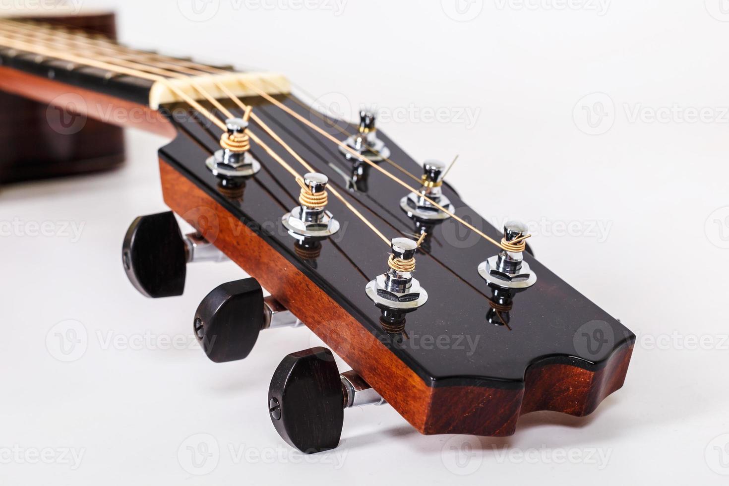 Tuning pegs on wooden machine head of six strings guitar on white background photo