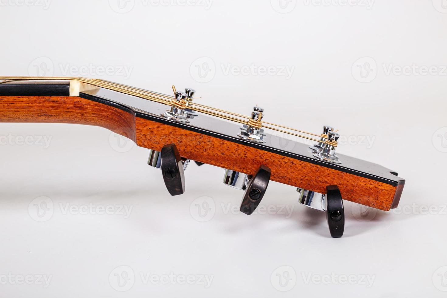 Tuning pegs on wooden machine head of six strings guitar on white background photo