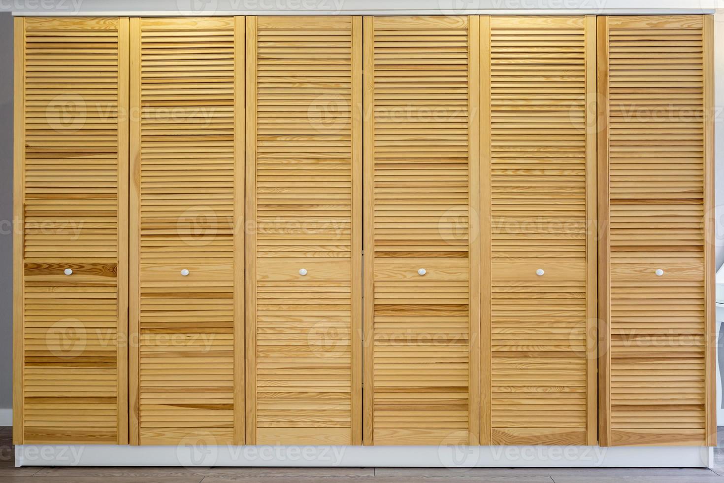 wardrobe made of thin wooden planks in apartment room. ecological furniture photo