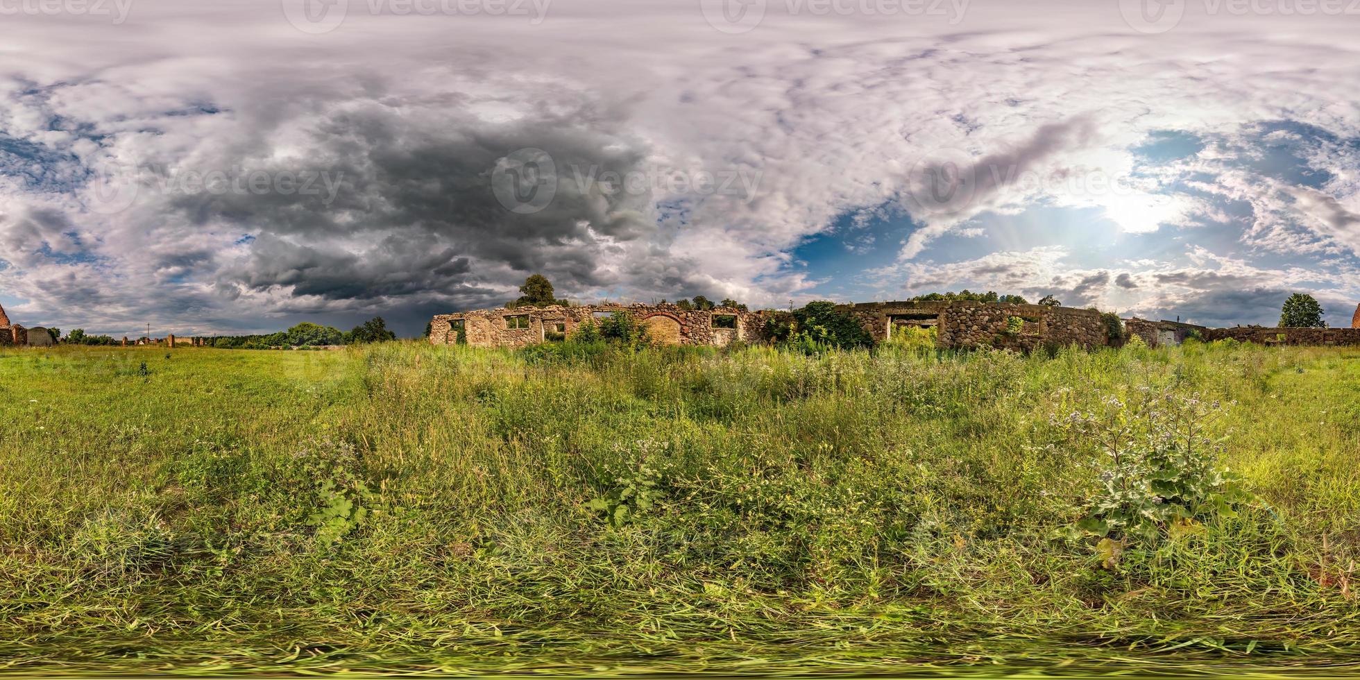 Full spherical seamless hdri panorama 360 degrees angle view near walls of abandoned ruined stone farm building with beautiful clouds in equirectangular projection, VR AR virtual reality content. photo