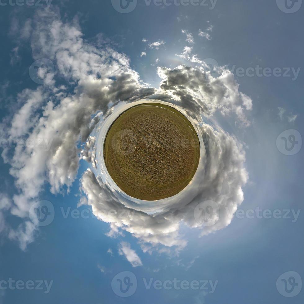 tiny planet in blue sky with sun and beautiful clouds. Transformation of spherical panorama 360 degrees. Spherical abstract aerial view. Curvature of space. photo