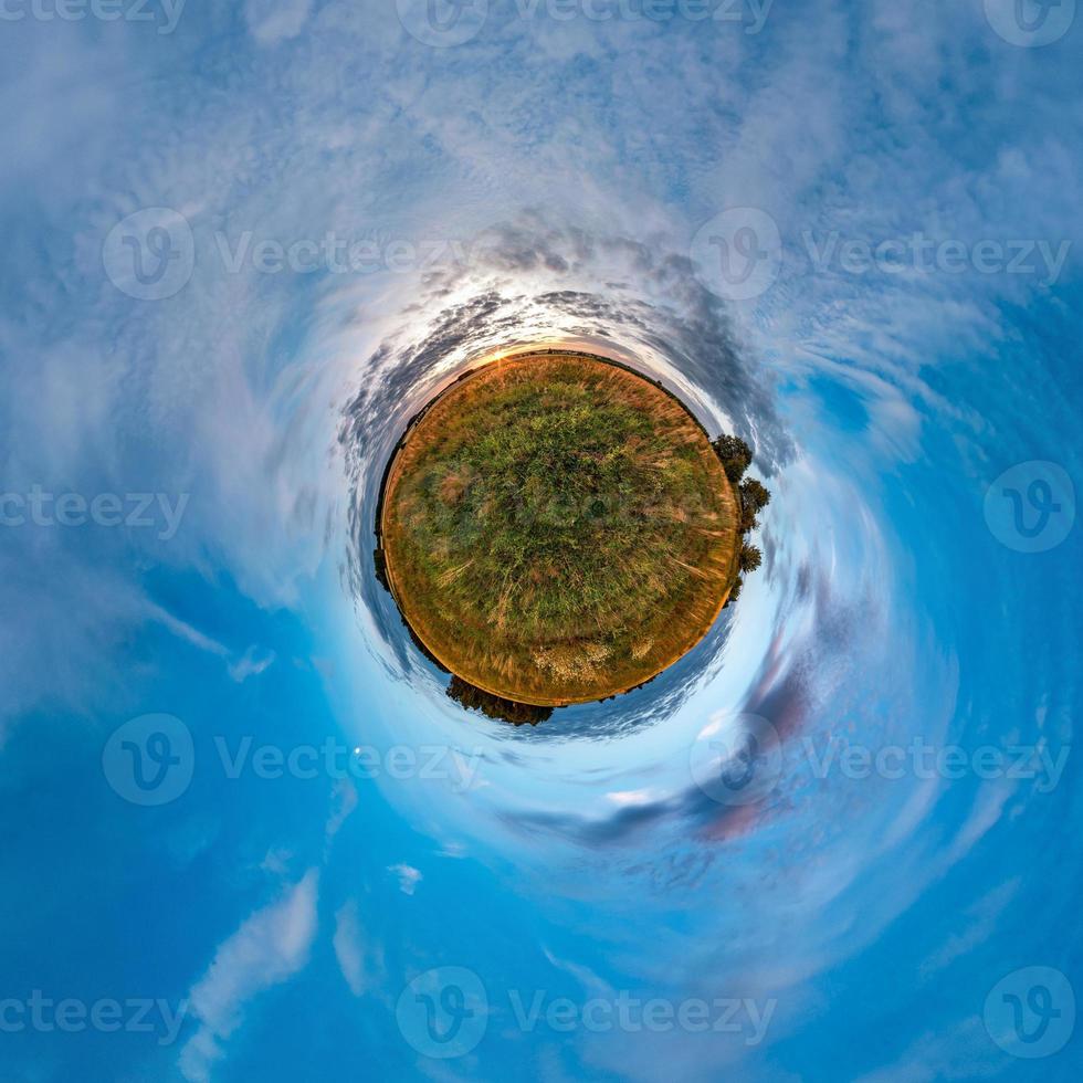 Little planet transformation of spherical panorama 360 degrees. Spherical abstract aerial view in field in nice evening with awesome beautiful clouds. Curvature of space. photo