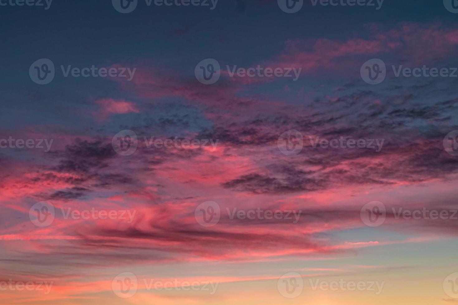 Blue violet red sunset sky background with evening fluffy curly rolling cirrostratus clouds. Good windy weather photo