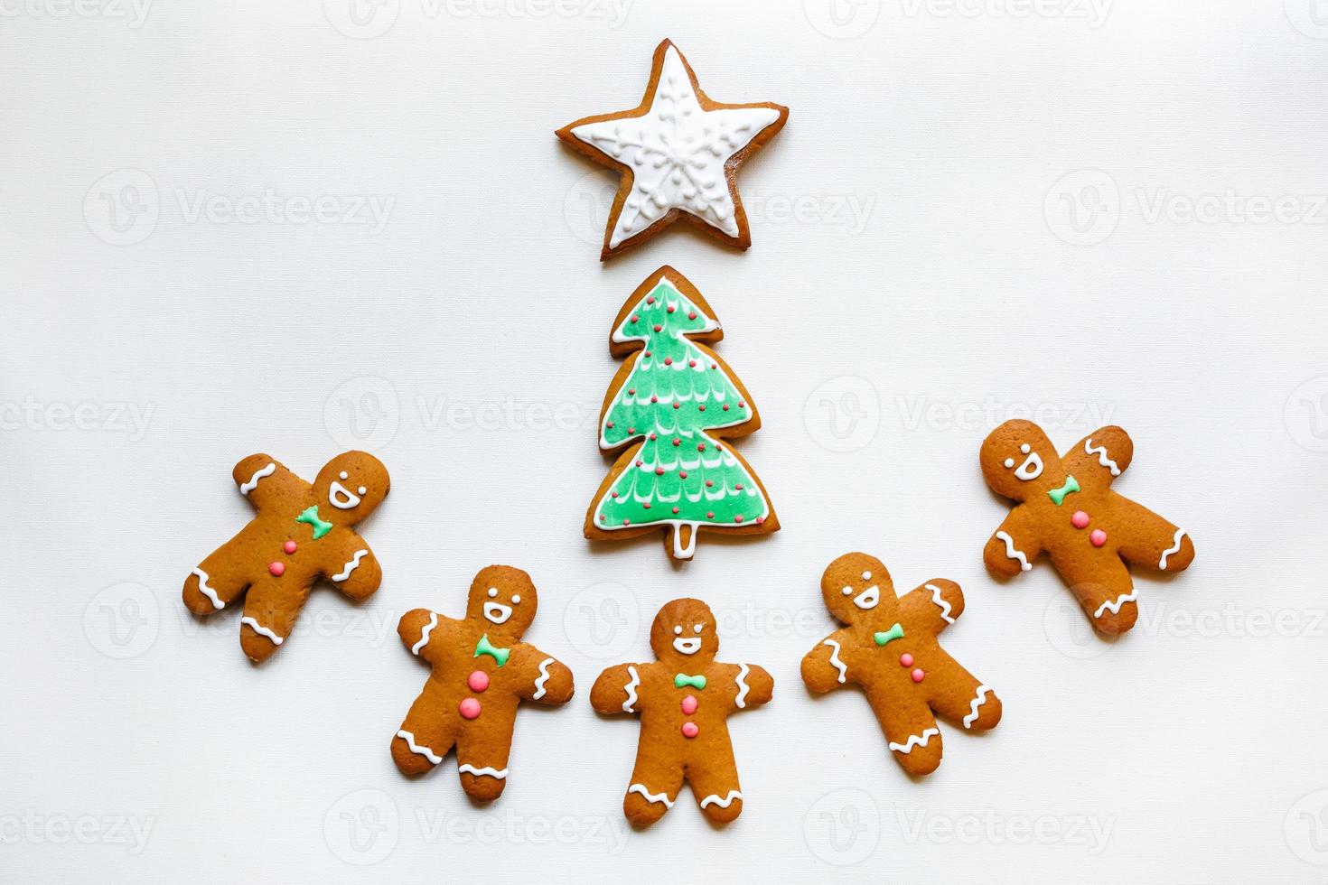 Handmade festive gingerbread cookies in the form of stars, snowflakes, people, socks, staff, mittens, Christmas trees, hearts for xmas and new year holiday on white paper background photo