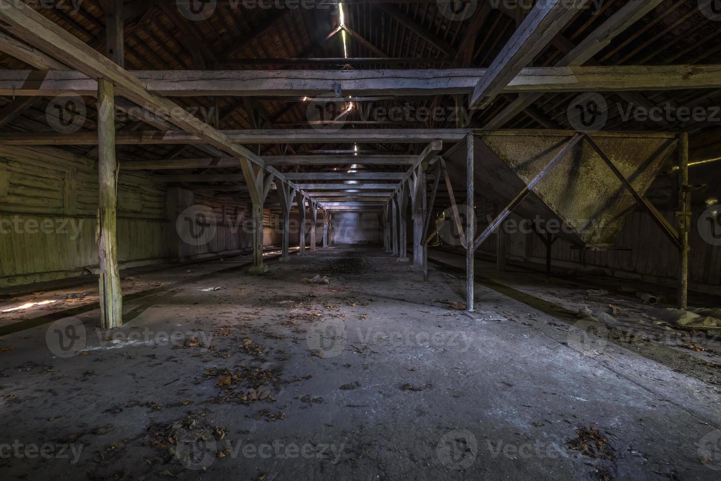 inside dark abandoned ruined wooden decaying hangar with rotting columns photo