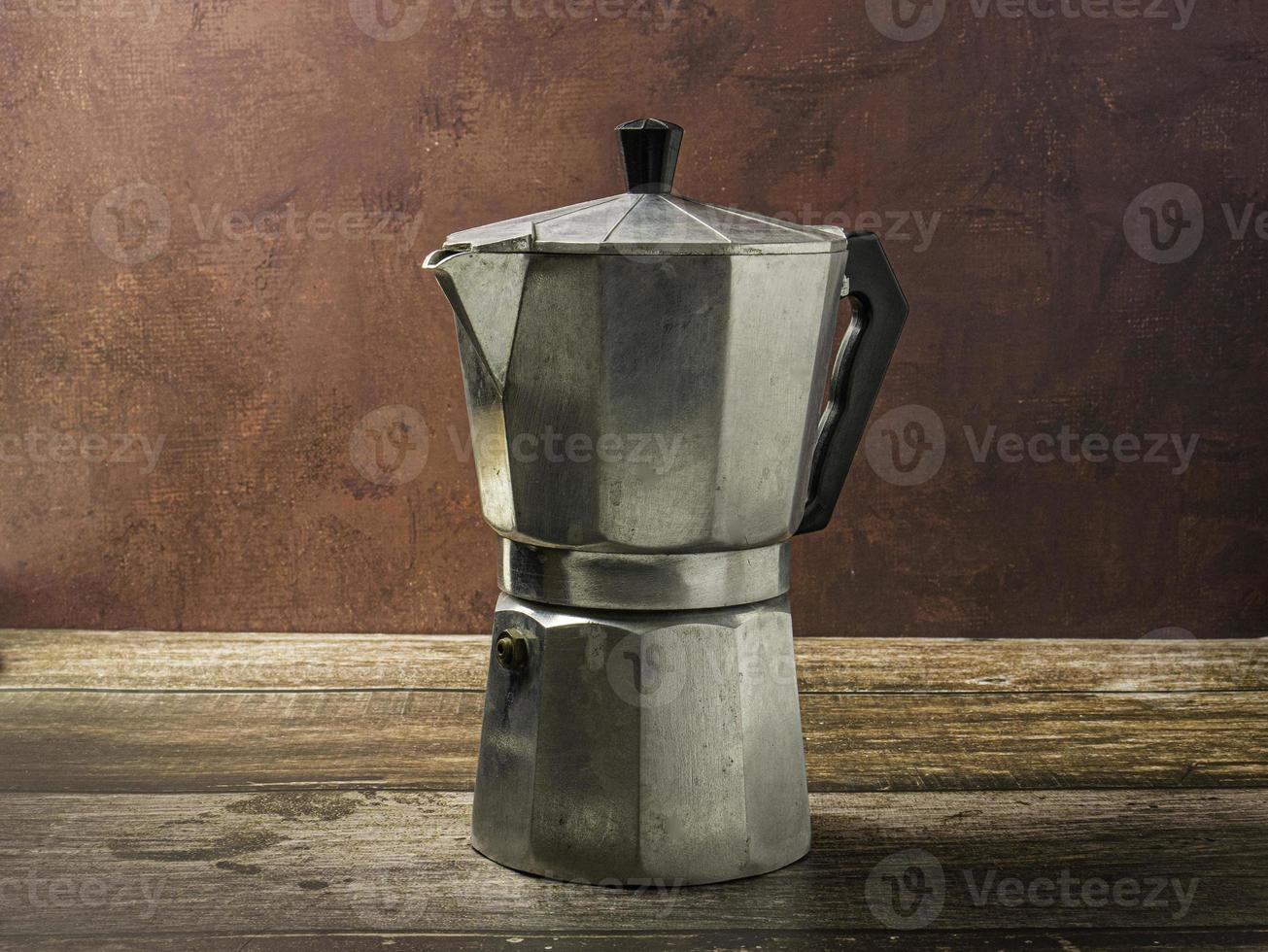 The Moka pot on wood table for hot drink concept photo