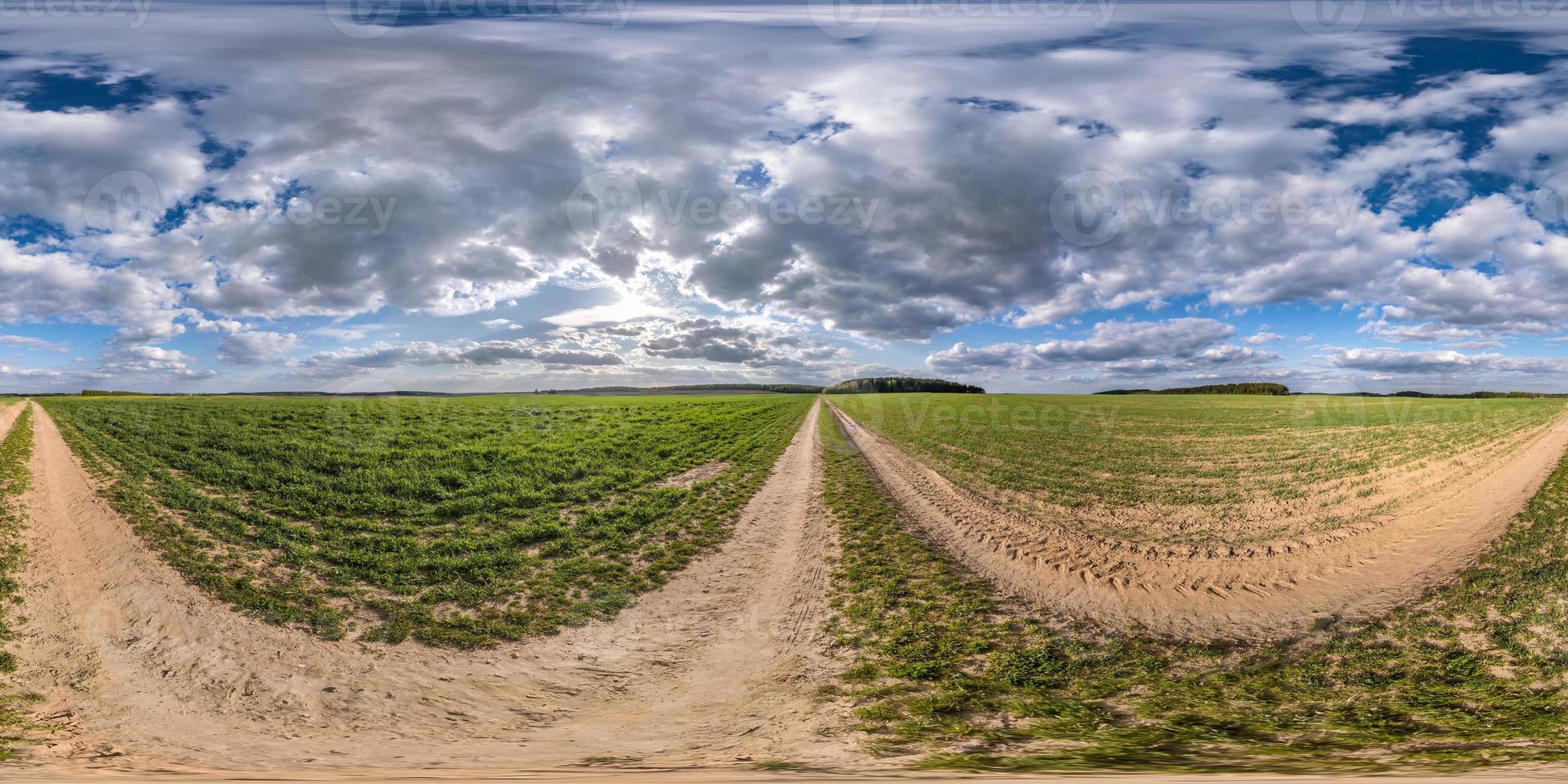 full seamless spherical hdri panorama 360 degrees angle view on no traffic gravel road among fields in spring day with cloudy sky in equirectangular projection, ready for VR AR virtual reality content photo