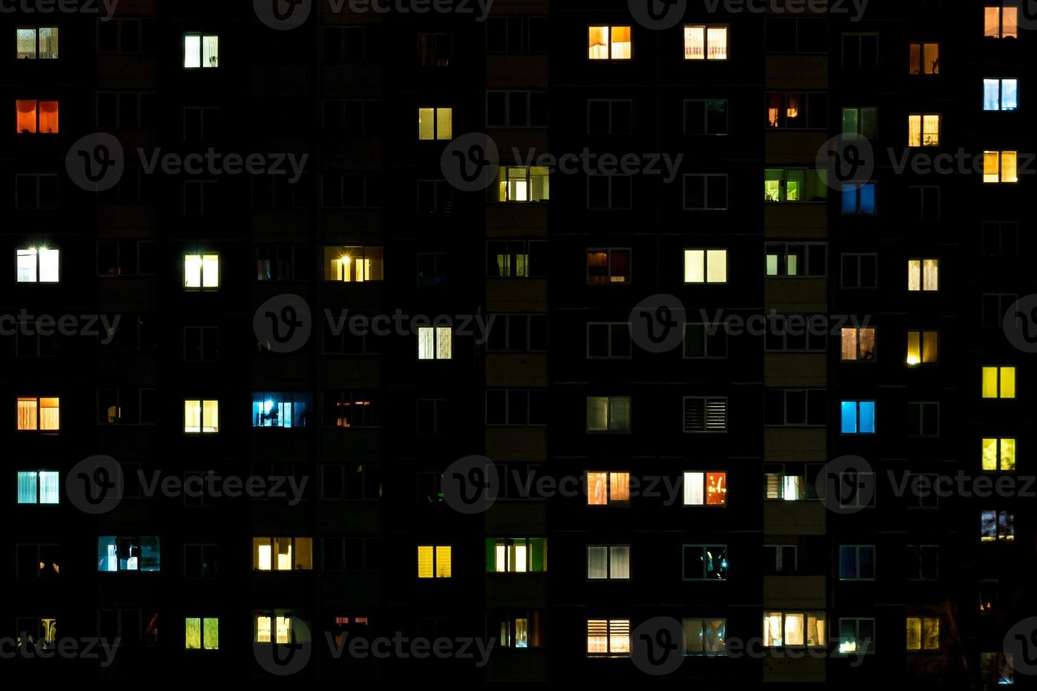 Night time lapse of Light in the windows of a multistory building. life in a big city photo