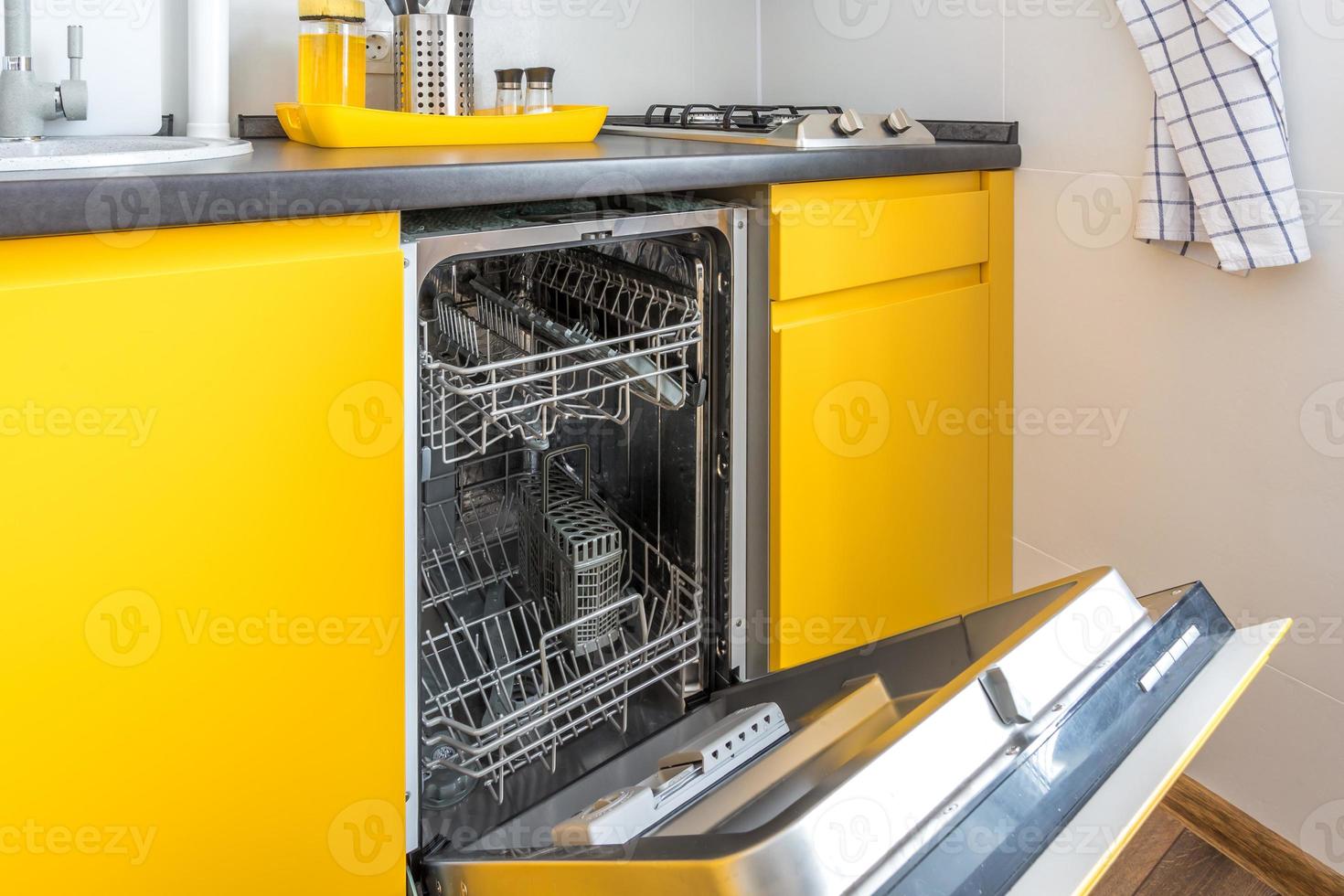 Interior of the modern kitchen with opened Dishwasher in loft flat apartment in minimalistic style with yellow color photo