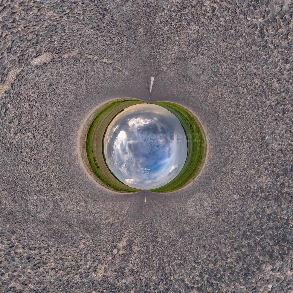 blue sky ball in middle of swirling asphalt road or field. Inversion of tiny planet transformation of spherical panorama 360 degrees. Spherical abstract view. Curvature of space. photo