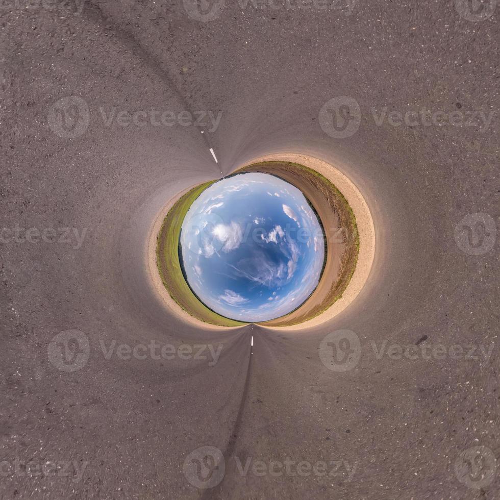 blue sky ball in middle of swirling asphalt road or field. Inversion of tiny planet transformation of spherical panorama 360 degrees. Spherical abstract view. Curvature of space. photo