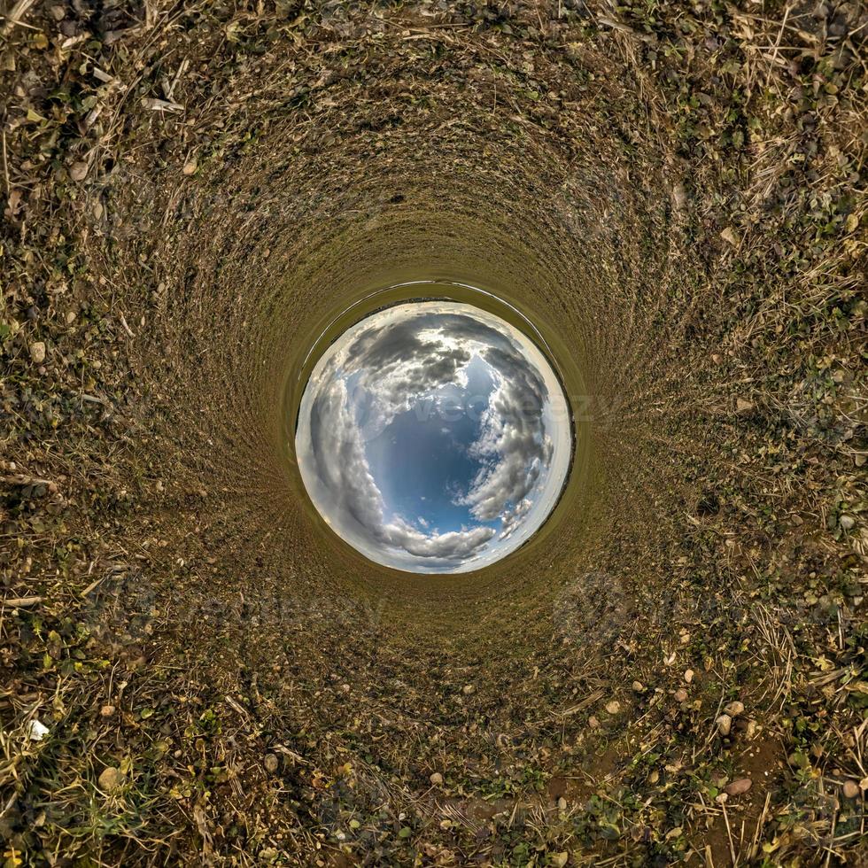 bola de cielo azul en medio del campo giratorio. inversión de la transformación del pequeño planeta del panorama esférico de 360 grados. curvatura del espacio. foto