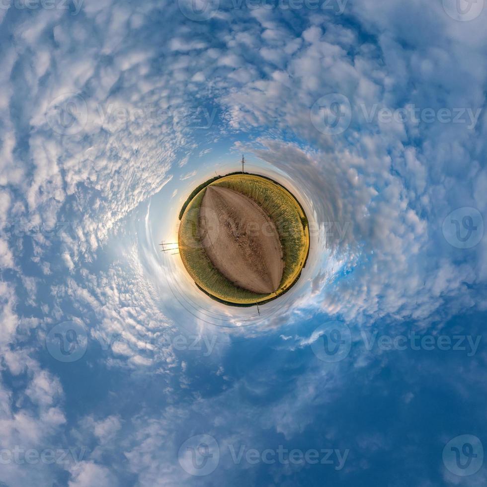 Little planet transformation of spherical panorama 360 degrees. Spherical abstract aerial view in field in nice evening with awesome beautiful clouds. Curvature of space. photo