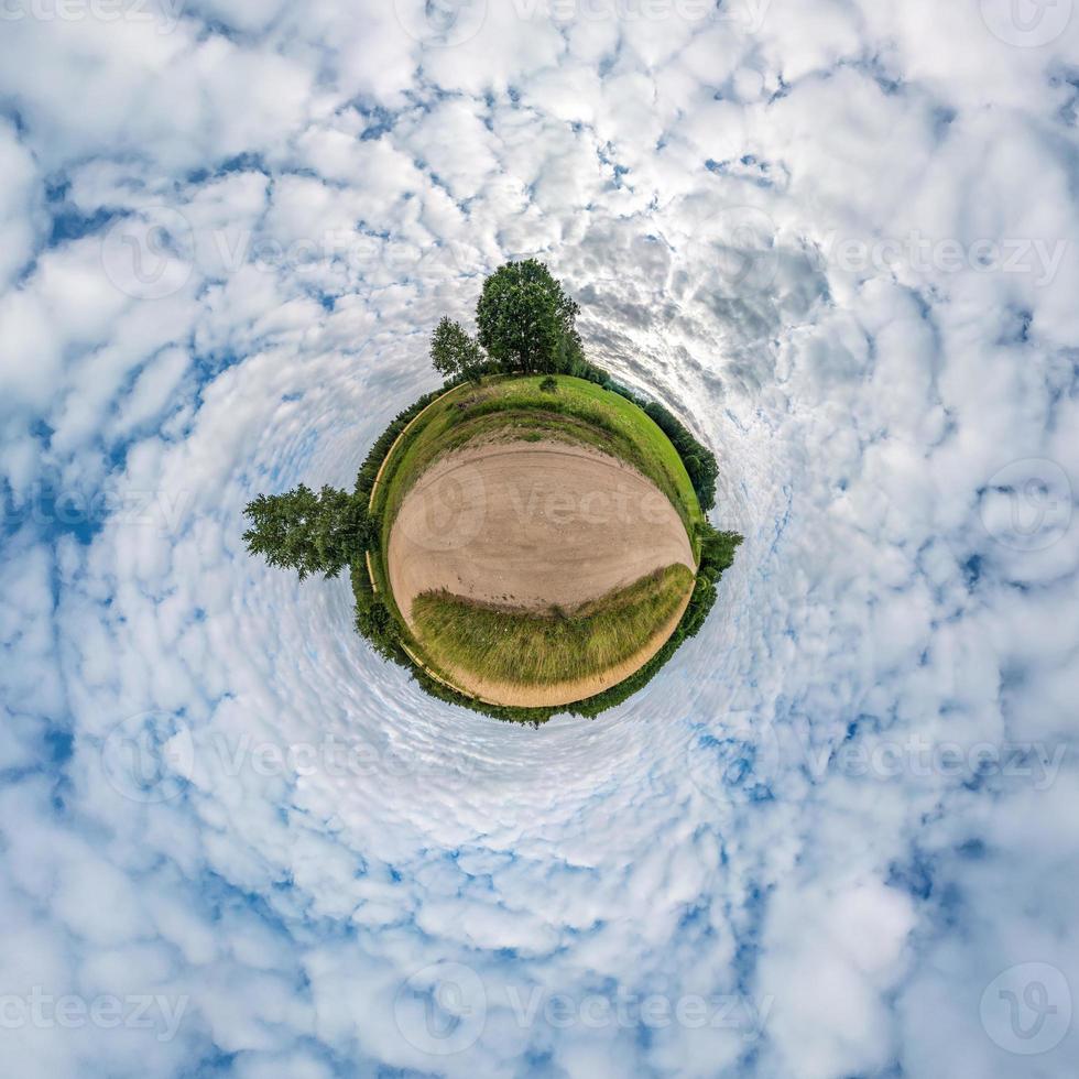 Little planet transformation of spherical panorama 360 degrees. Spherical abstract aerial view in field in nice evening with awesome beautiful clouds. Curvature of space. photo