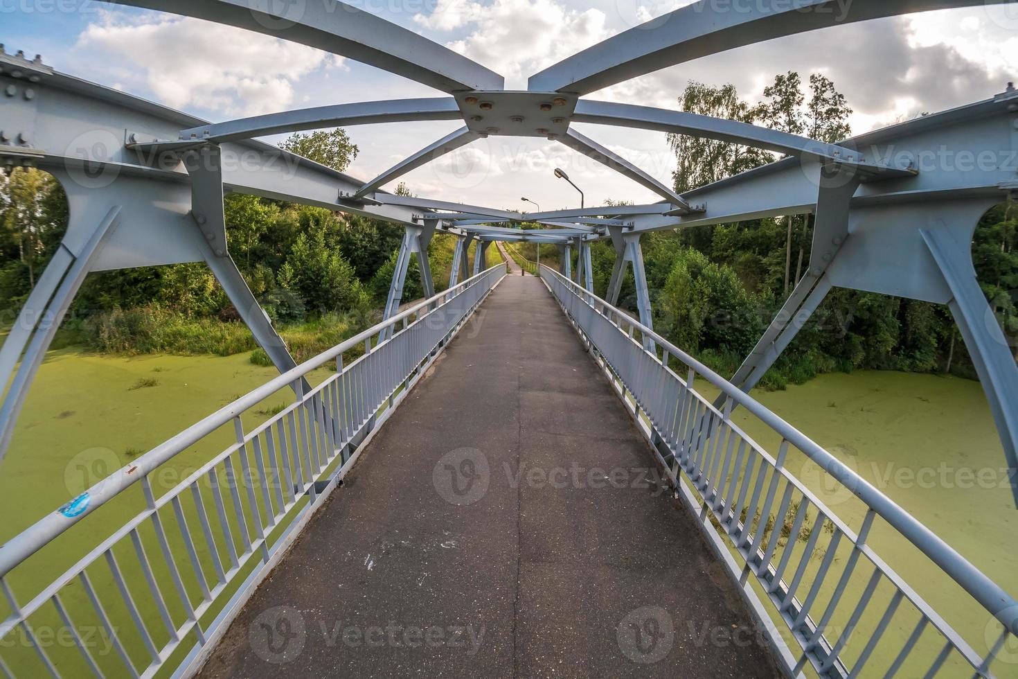 iron steel frame construction of pedestrian bridge across the river photo