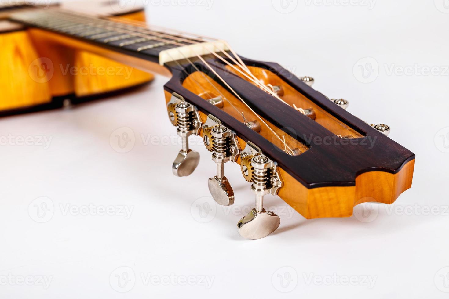 Tuning pegs on wooden machine head of six strings guitar on white background photo
