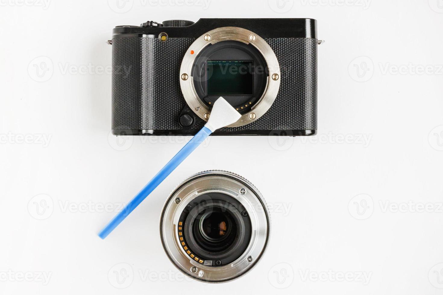 Close-up of mirrorless digital APS-C dirty camera matrix sensor cleaning and maintenance with swab, photographer cleaning photocamera on white background photo