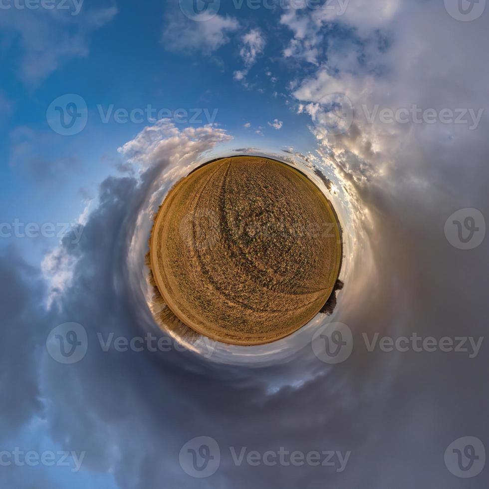 tiny planet in blue sky with sun and beautiful clouds. Transformation of spherical panorama 360 degrees. Spherical abstract aerial view. Curvature of space. photo