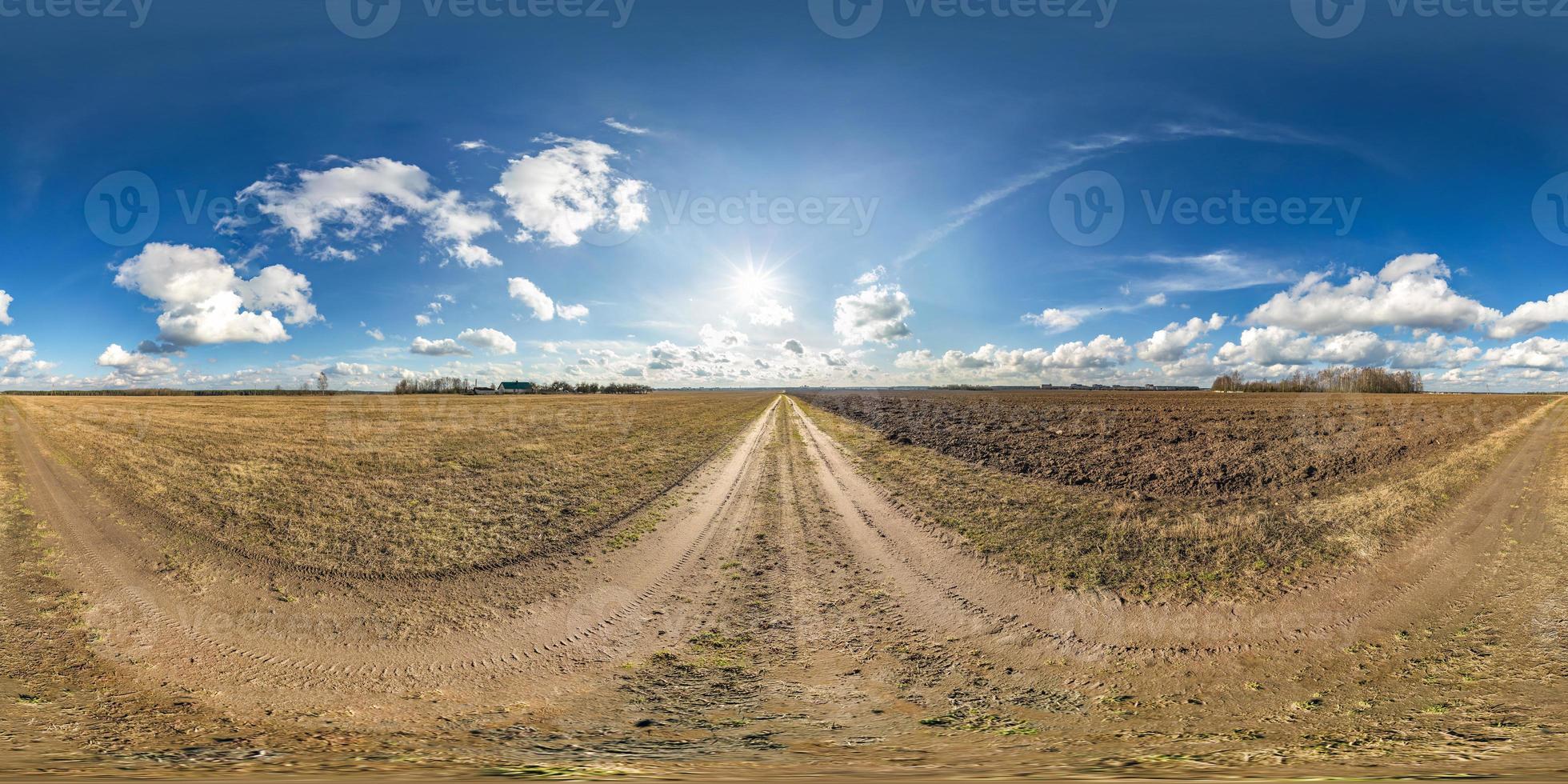 full seamless spherical hdri panorama 360 degrees angle view on no traffic gravel road among fields in spring day with cloudy sky in equirectangular projection, ready for VR AR virtual reality content photo