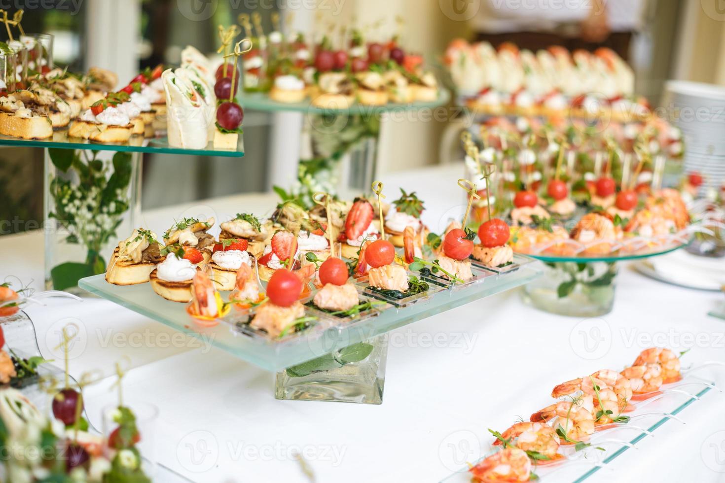 abastecimiento. comida fuera del sitio. mesa de buffet con varios canapés, sándwiches, hamburguesas y bocadillos. foto