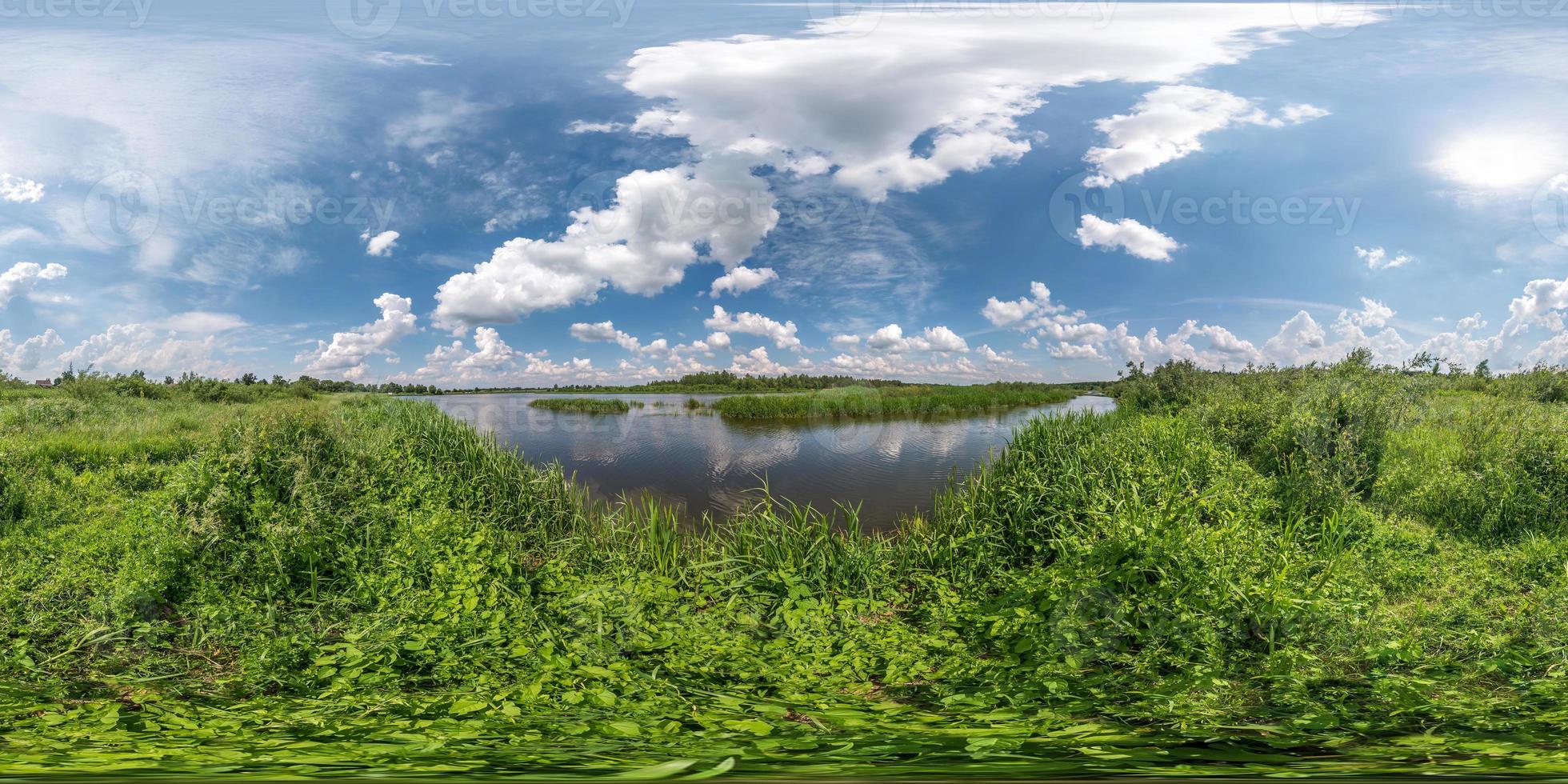 full seamless spherical hdri panorama 360 degrees angle view on grass coast of huge lake or river in sunny summer day and windy weather with beautiful clouds in equirectangular projection, VR content photo