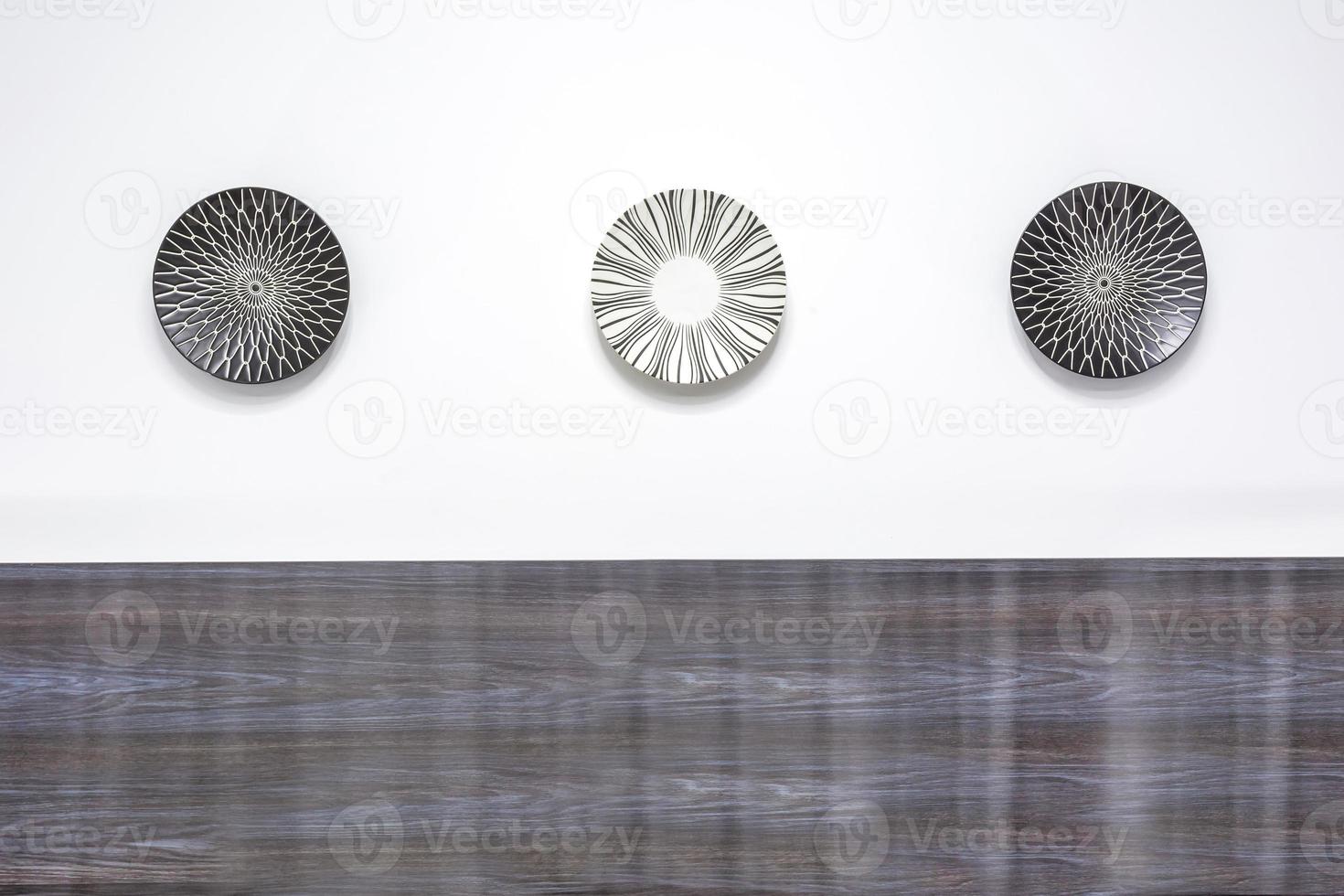 three painted plates on a white wall in modern apartments photo