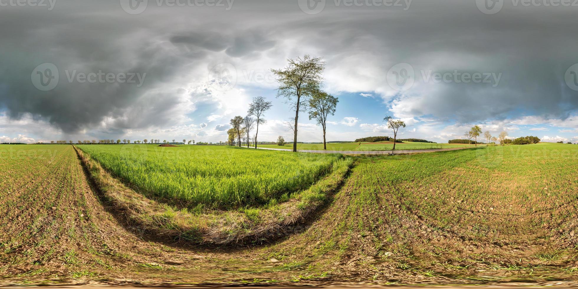 full seamless spherical panorama 360 degrees angle view near asphault road among meadow fields in after storm with awesome clouds in equirectangular projection, VR AR virtual reality content photo