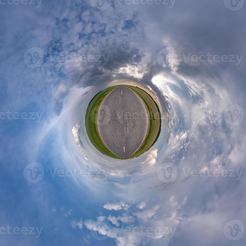 tiny planet in blue sky with sun and beautiful clouds. Transformation of spherical panorama 360 degrees. Spherical abstract aerial view. Curvature of space. photo