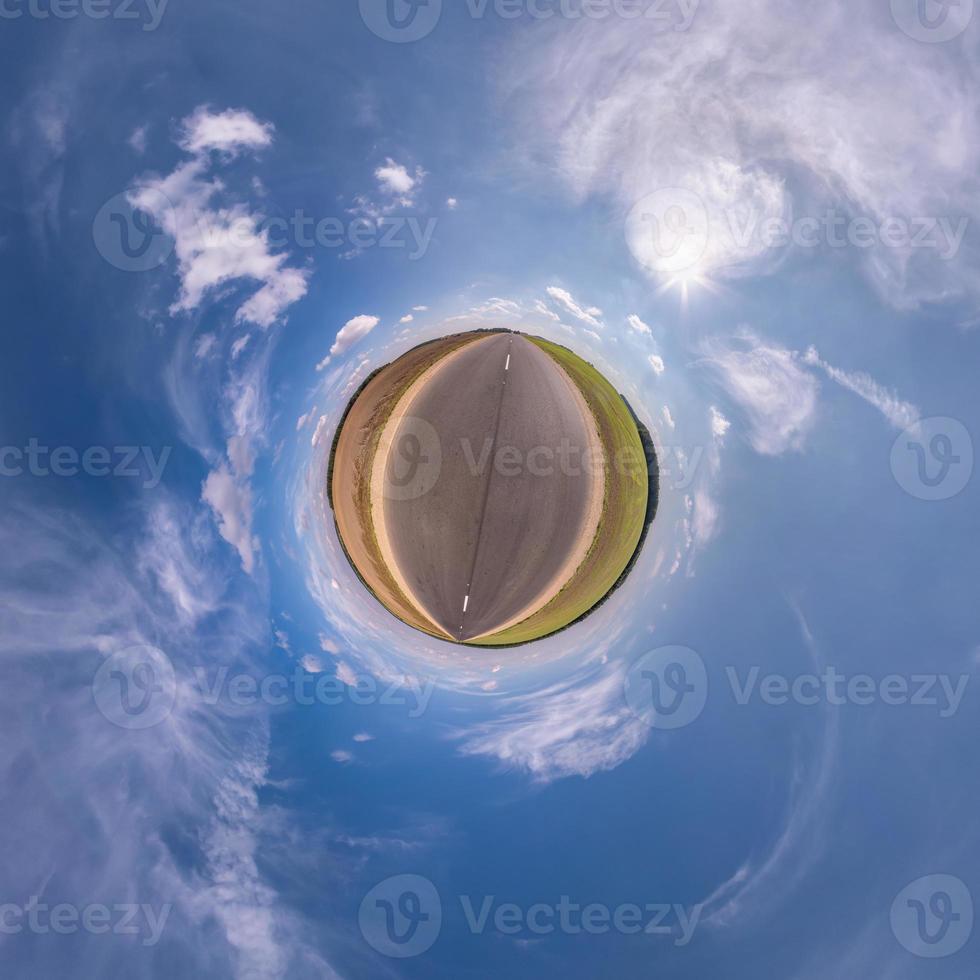 tiny planet in blue sky with sun and beautiful clouds. Transformation of spherical panorama 360 degrees. Spherical abstract aerial view. Curvature of space. photo