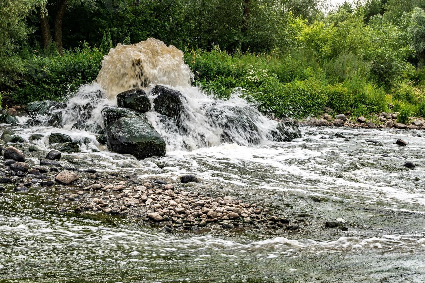 mixing zone of sewage discharge of urban sewage. river pollution. city dumps. artificial geyser. long exposure photo