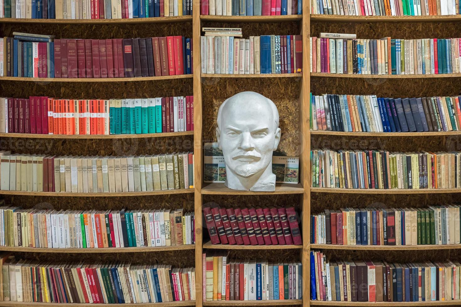 bust the head of the proletariat leader Lenin in the library on a shelf with books photo