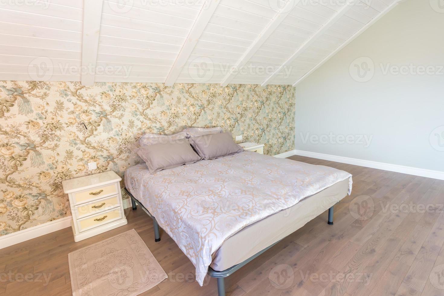 Double bed with pillows in interior of the modern bedroom in loft flat in light color style of expensive apartments photo
