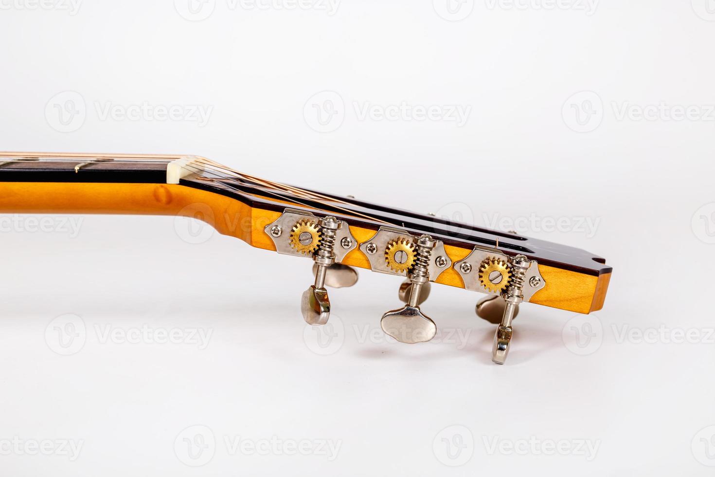 Tuning pegs on wooden machine head of six strings guitar on white background photo