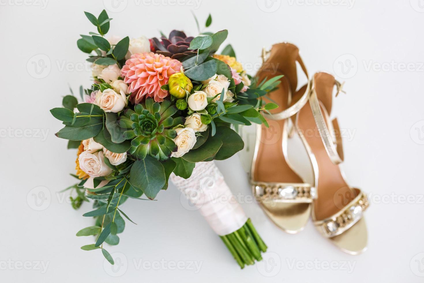 bright wedding bouquet of summer dahlias and roses with women high-heeled shoes photo