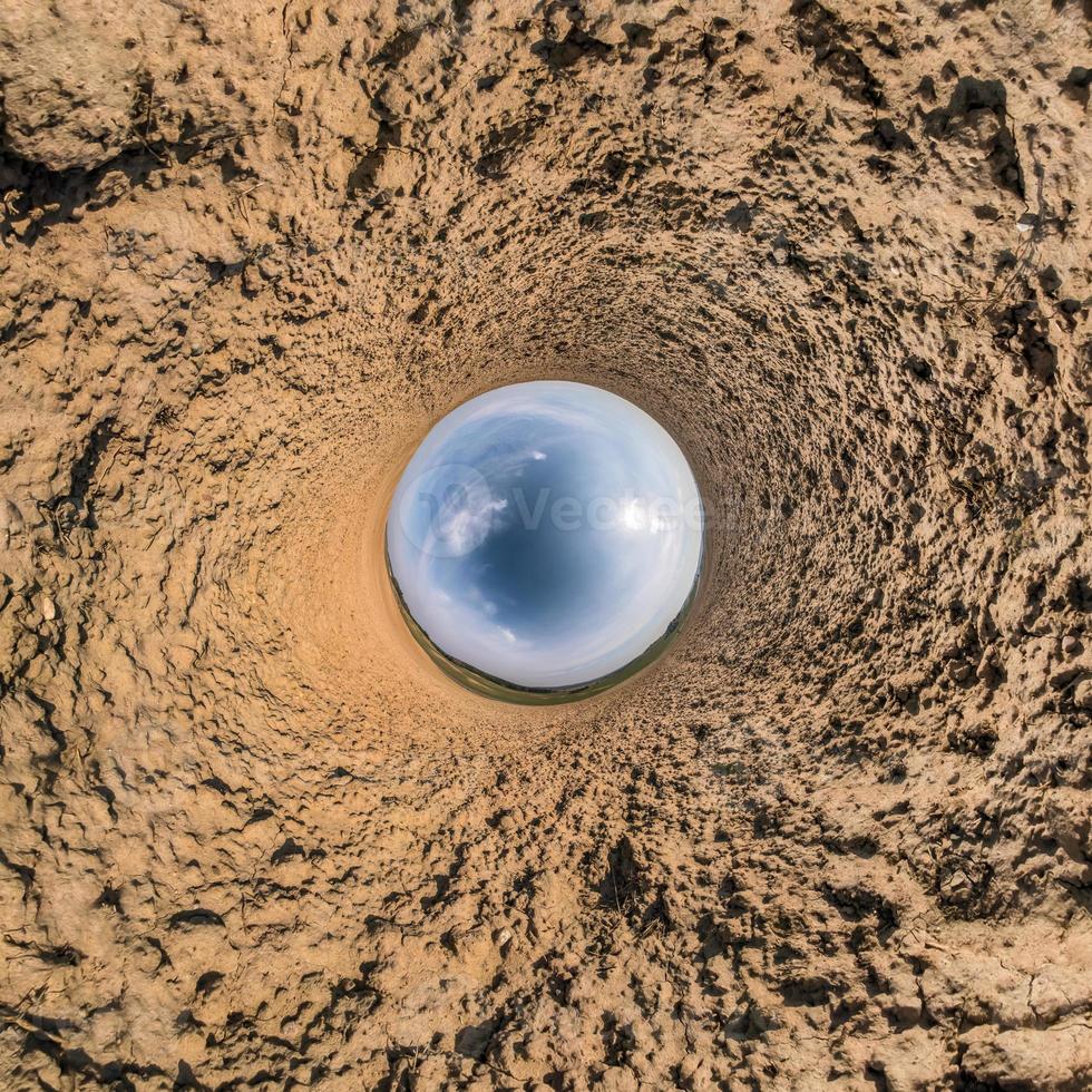 Little planet transformation of spherical panorama 360 degrees. Spherical abstract aerial view in field with awesome beautiful clouds. Curvature of space. photo