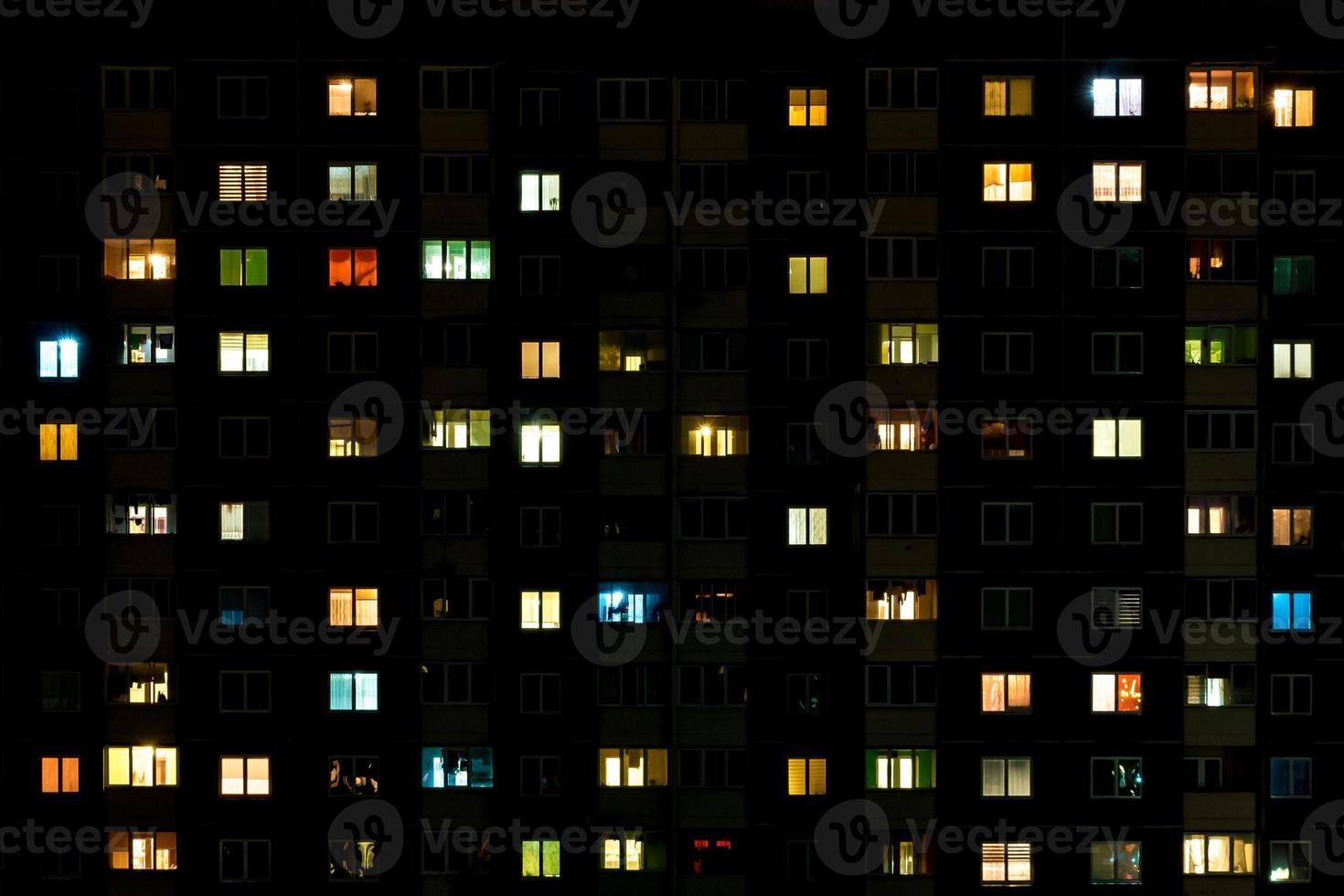 Night time lapse of Light in the windows of a multistory building. life in a big city photo