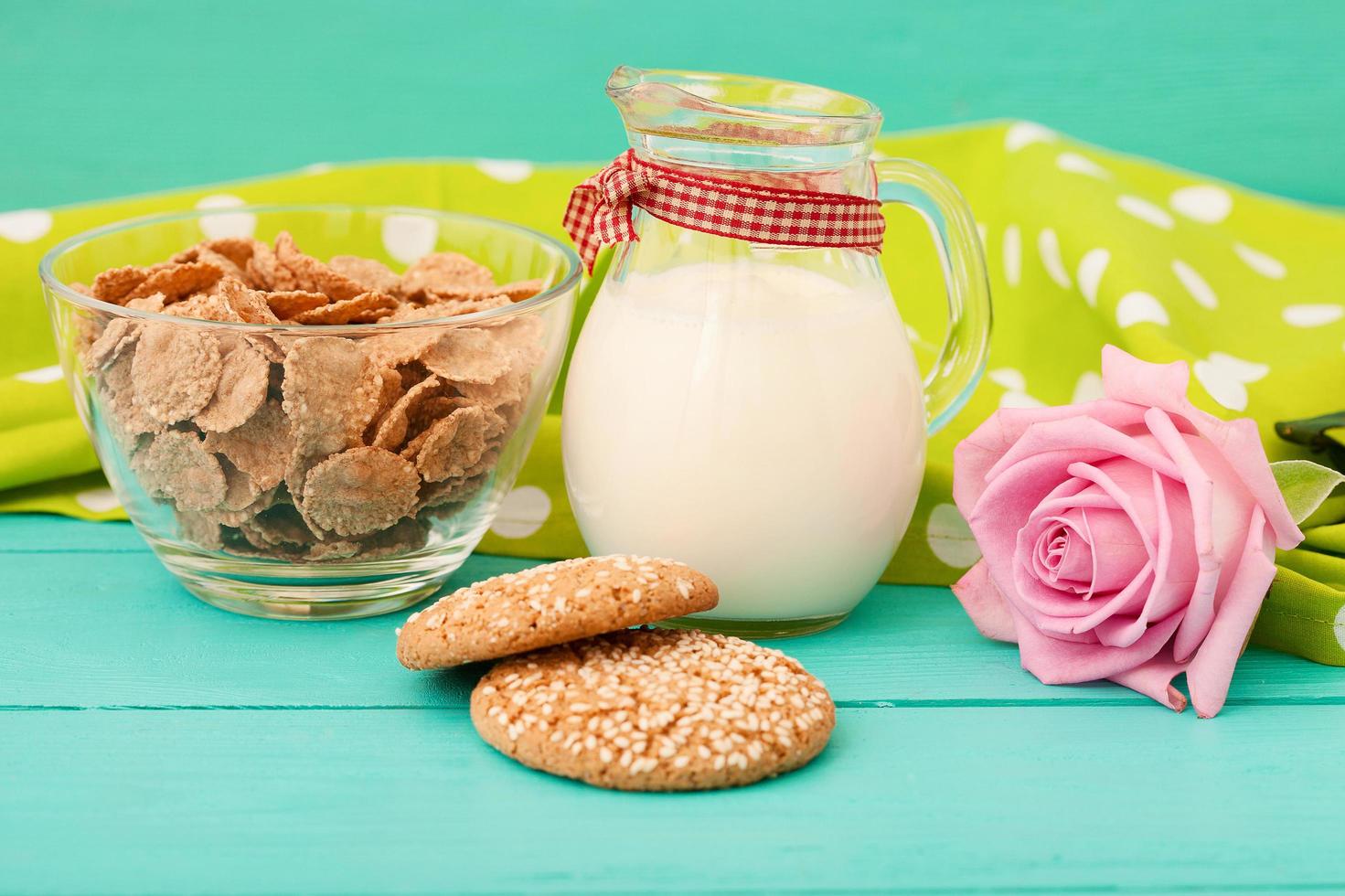 Milk, cookie, oat flakes. Breakfast and pink rose on blue wooden background and lace napkin. Top view and copy space. Mothers day. photo