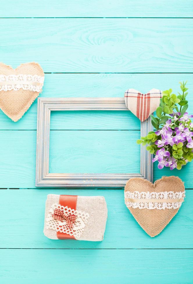 Romantic frame with copy space and accessories on blue wooden background. Top view photo