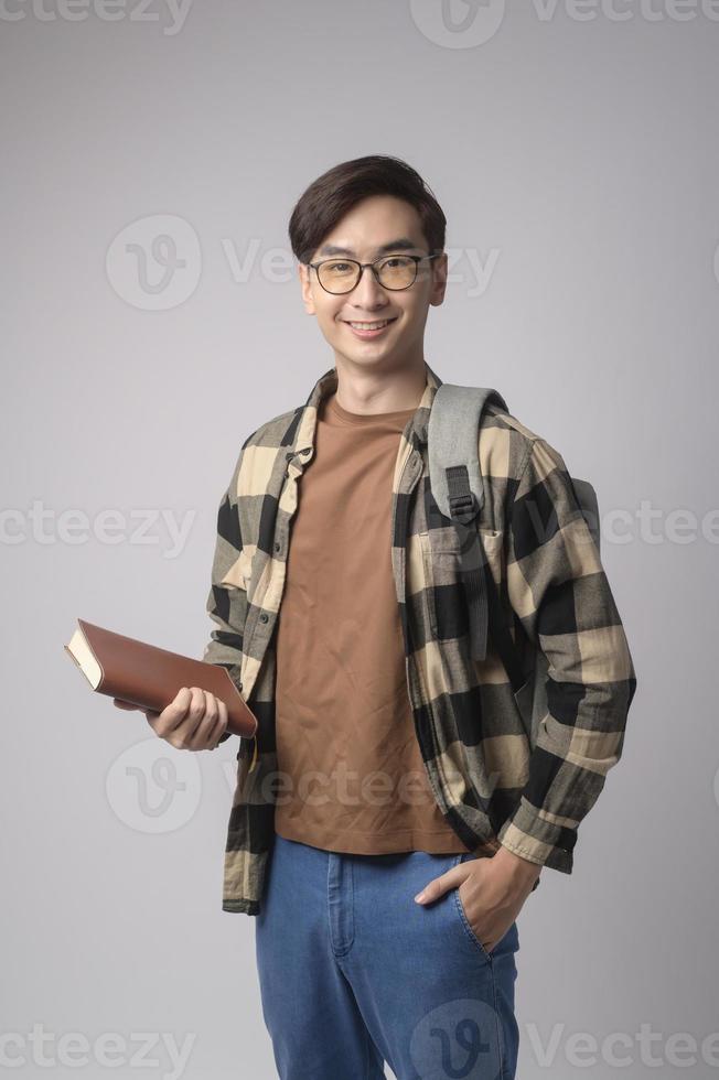 Portrait of an Asian university student over white background studio, education concept. photo